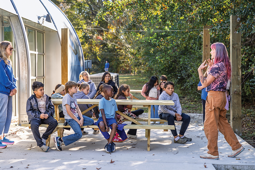 Maddy VanMiddlesworth speaks to a group of Rock Ridge Elementary students about soil in the outdoor classroom at the North Carolina Museum of Natural Sciences at Contentnea Creek.