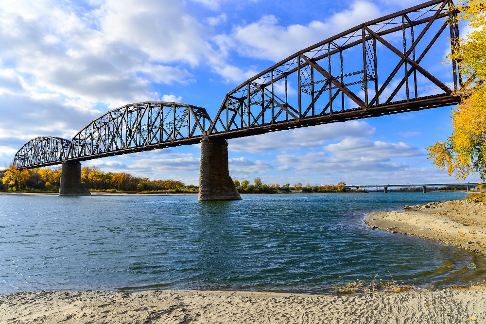 A railroad bridge stretches across the Missouri River near downtown Bismarck, ND.