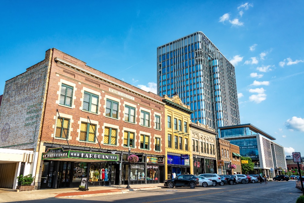 A modern high rise is juxtaposed against the lower-profile buildings of the historic downtown in Fargo, ND.