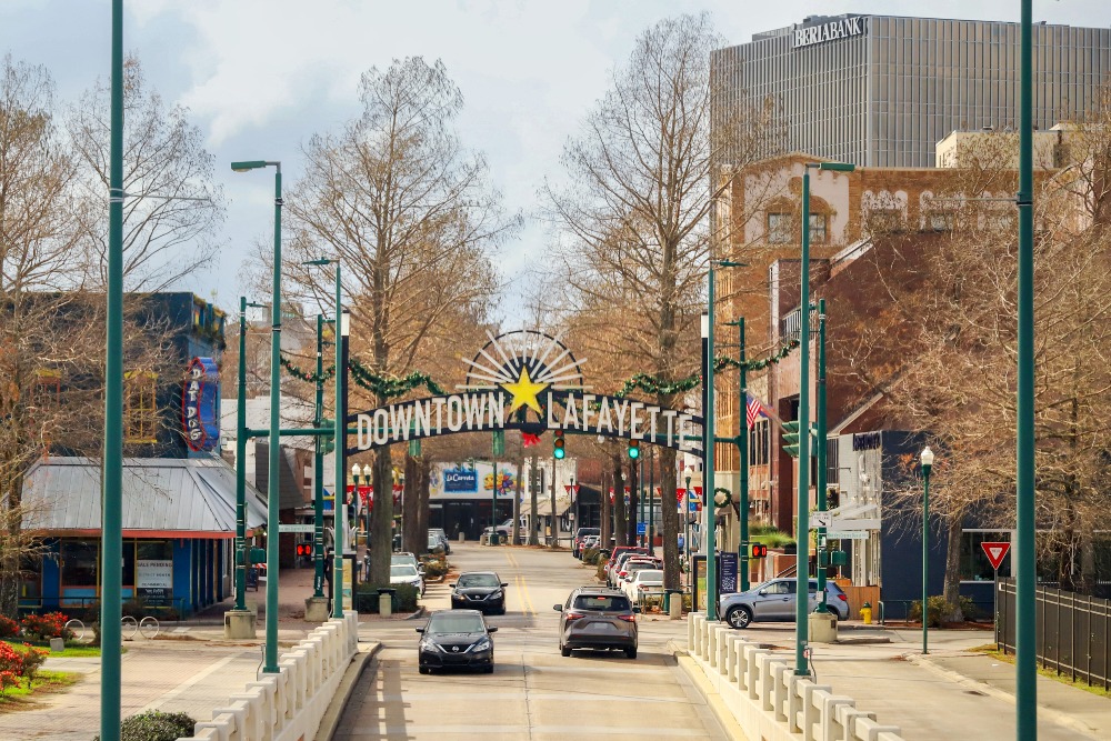 Streetlights frame a sign welcoming visitors to downtown Lafayette, Louisiana.