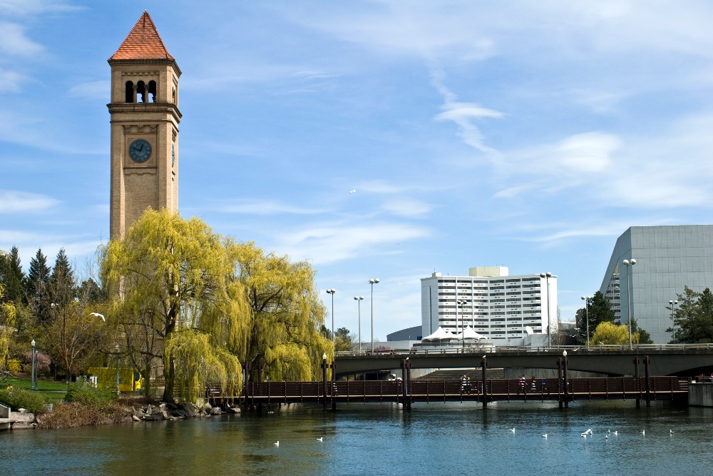 Weeping willows, bridges and a clock tower frame a view of Riverfront Park in Spokane, Washington.