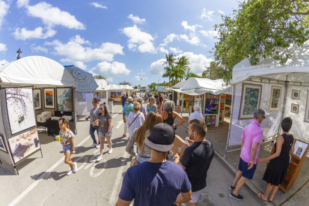 Miami, Florida, USA - February 21, 2022: Nationals and Internationals tourists and Collectors enjoying President's Day National Holidays at Coconut Art Festival; looking to buy some pieces of Arts in a sunny summer day at Regatta Park in Coconut Grove's neighborhood.