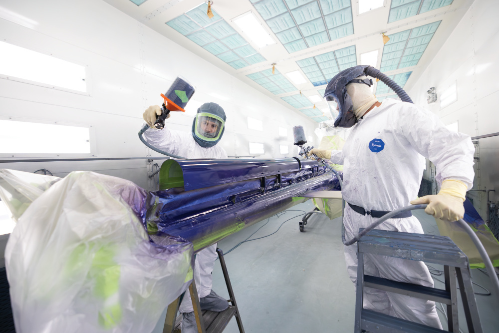 Employees paint the tail of a helicopter at Bell (Textron) Piney Flats in Piney Flats, Tennessee. 