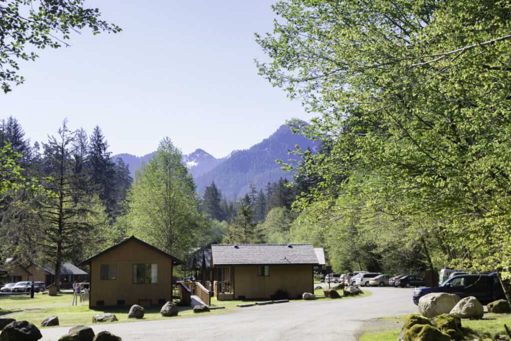 "Port Angeles, USA - May 26, 2012: Chalets at the Sol Duc Hot Springs resort in the Sol Duc Valley, part of the Hoh Rainforest in Olympic National Park, Washington. A few visitors to the resort are around the chalets."