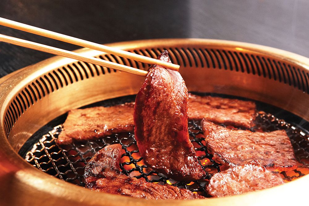 Japanese yakiniku is grilled at the table and turned with chopsticks.