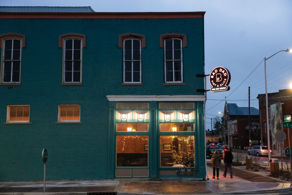 Bad Dad Pizzeria & Taproom lights up at dusk in downtown Richmond, Indiana.
