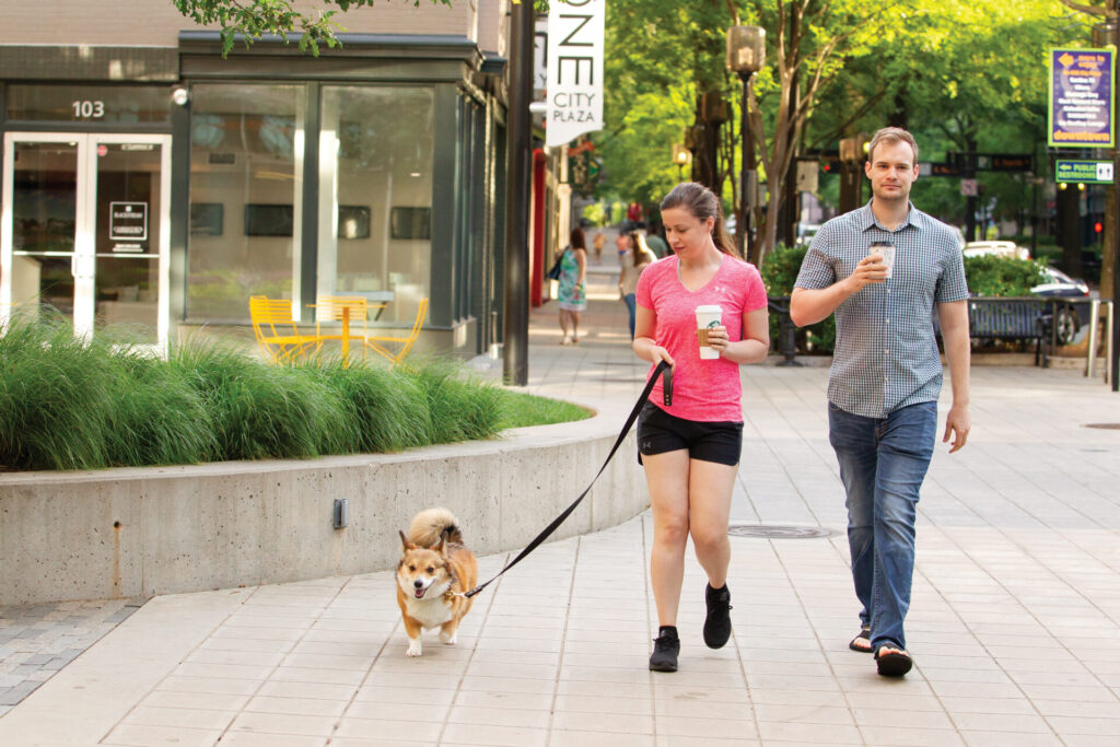 People walking dog in downtown Greenville, S.C.