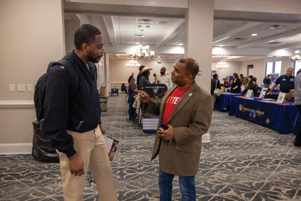 Hampton Roads Veterans Employment Center Director Sultan Camp, right, talks with Timothy Wilcox of the Navy during a forum for military members transitioning to the private sector at Langley Air Force Base in Hampton.