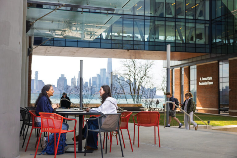 Students meet outdoors with a view of Manhattan at Stevens Institute of Technology in Hoboken, NJ