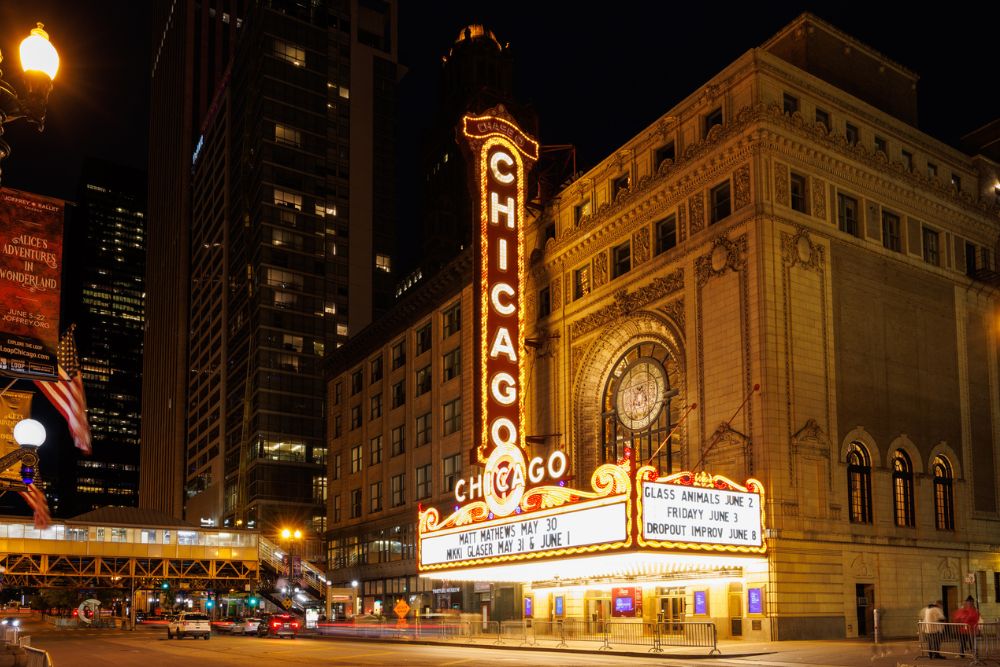 Vibrant glowing red marquee sign of the historic Chicago Theatre at night.