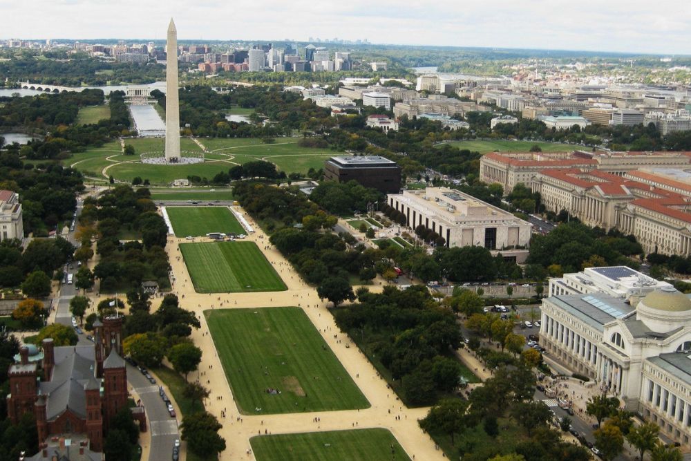 Aerial view looking down the length of the National Mall featuring the Washington Monument and Smithsonian museums.