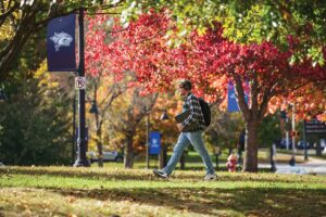 Student listens to music while walking on campus during the fall at University of New Hampshire.