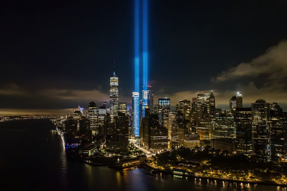 Two bright blue beams of light shining into the night sky from the National September 11 Memorial in New York City.