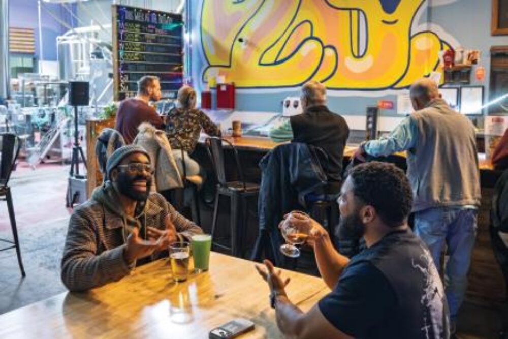 Lawrence Williams, left, and Christopher Roberts talk at Oozlefinch Beers in Hampton.