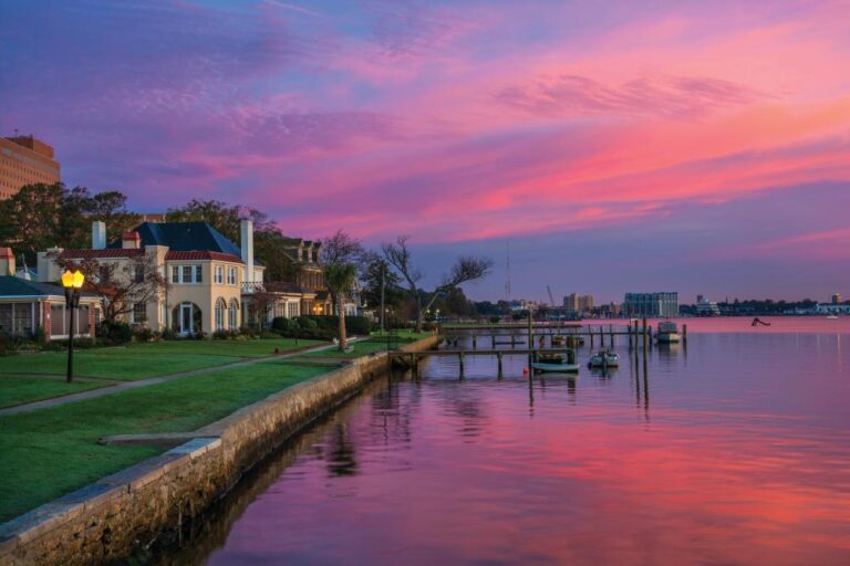 Houses and Riverfront of the Elizabeth River in Portsmouth, Virginia during dawn with magenta, purple, and pink clouds. Portsmouth, VA is part of the Virginia Beach / Hampton Roads metropolitan area.