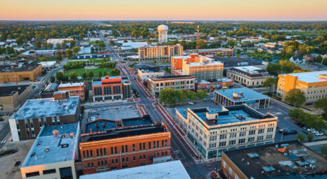 Image of Downtown Muncie Indiana aerial at dawn with yellow sunrise lighting on buildings and water tower