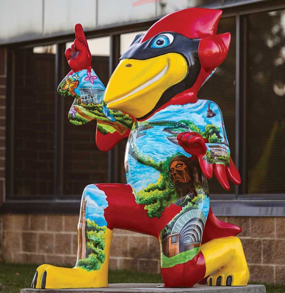 Painted Cy mascot statue on a sidewalk in Ames Iowa public art tour.
