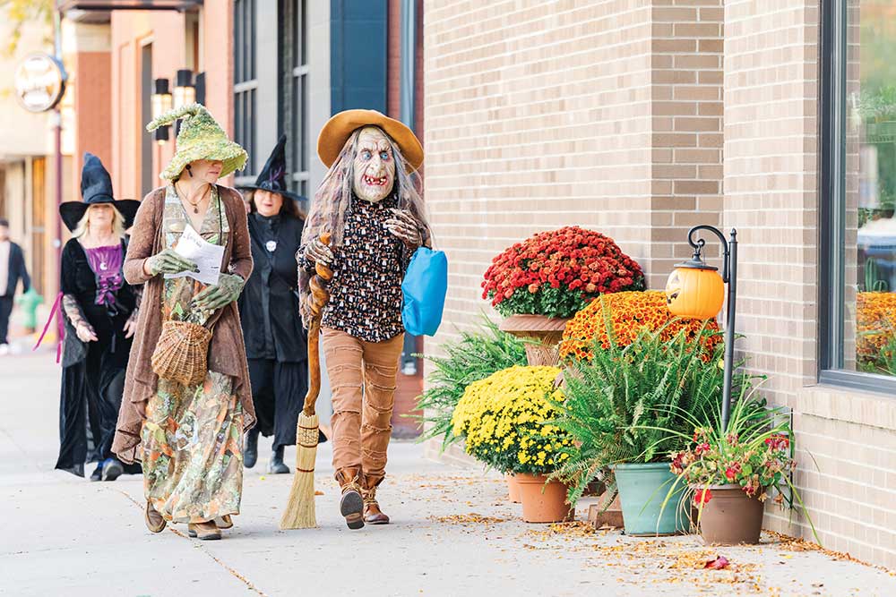 People walk the sidewalks during Witches Walk.