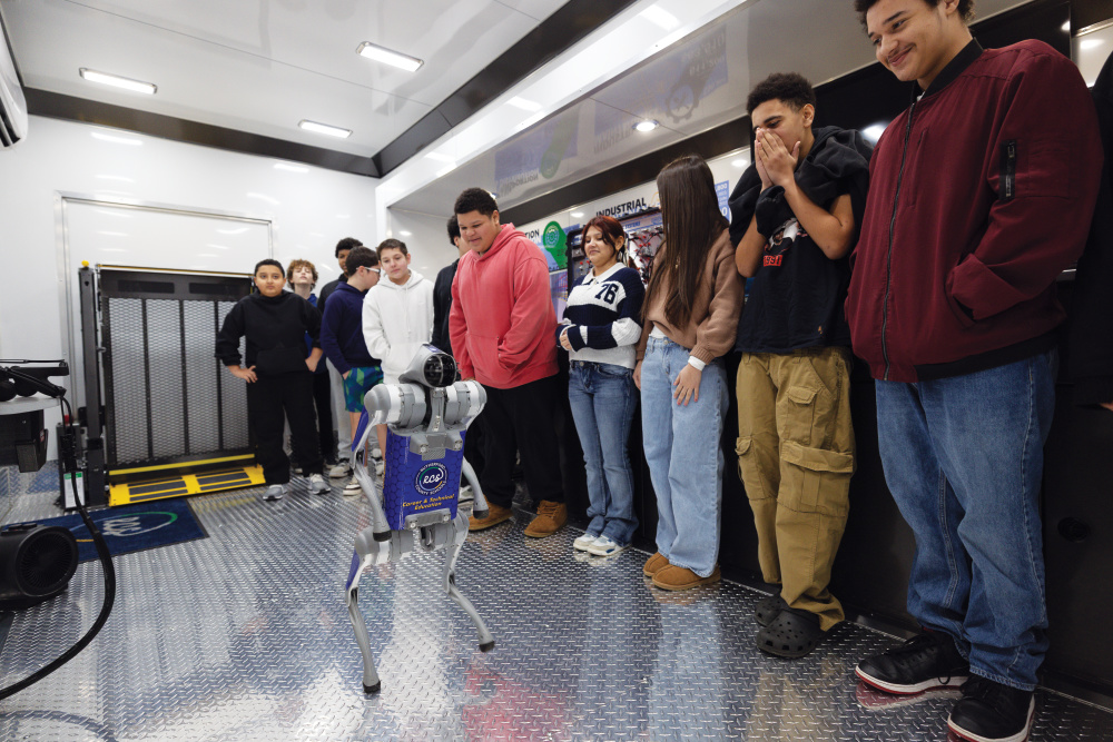 Students watch a robotic dog stand on its hind legs inside one of Rutherford County ISD's mobile learning lab at Whitworth Buchanan Middle School.