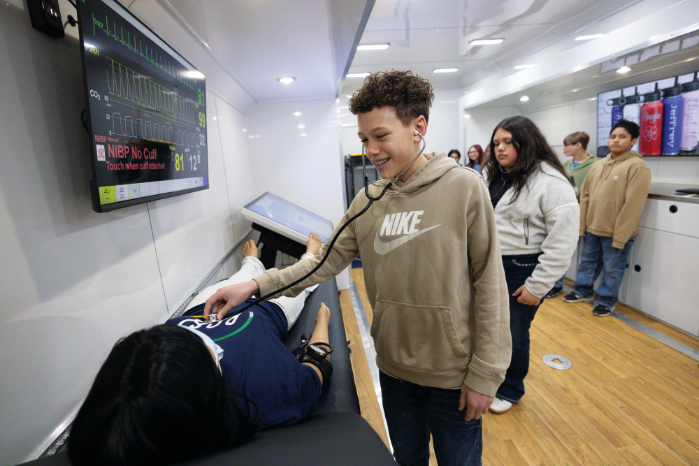 Student Tytus Buchanan listens to a simulated patient's vital signs inside one of Rutherford County ISD's mobile learning labs as it visits Whitworth Buchanan Middle School.