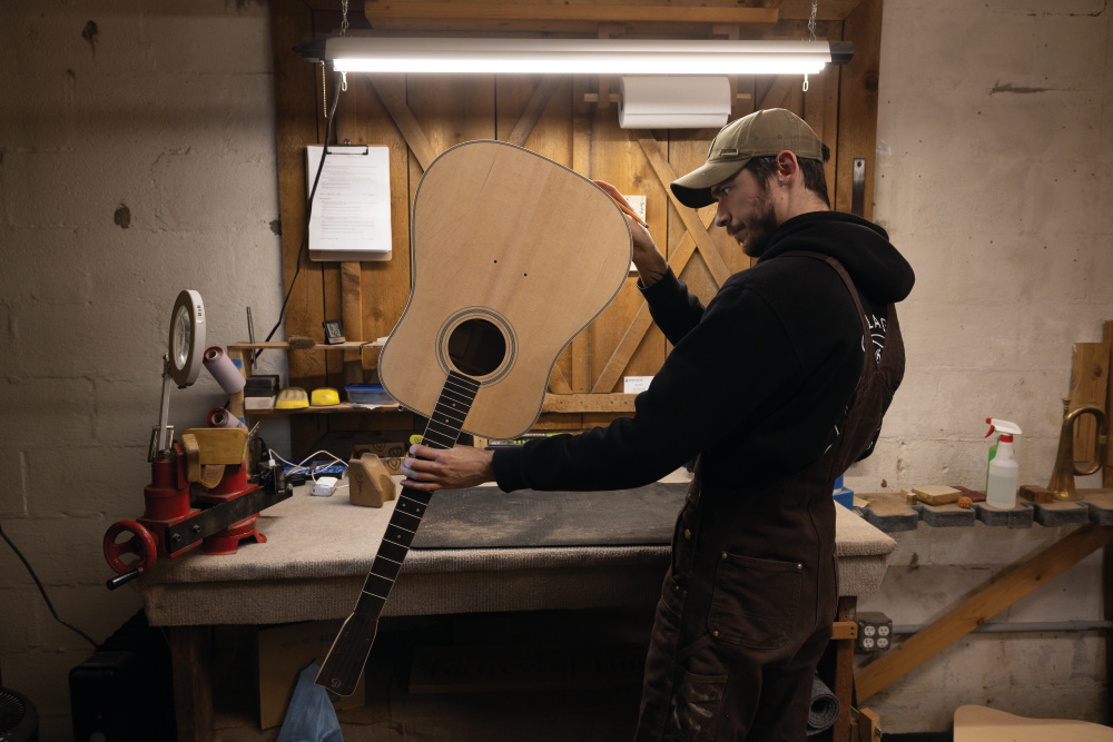 Charlie Sloan works on the finish of a Doc Watson style guitar at Gallagher Guitars in Murfreesboro.