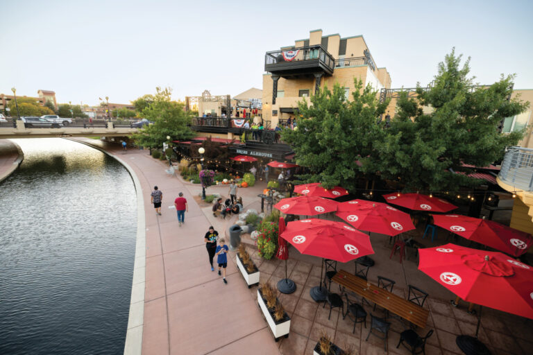Visitors walk along the Pueblo Riverwalk past Brues Alehouse Brewing Company in downtown Pueblo, Colorado.