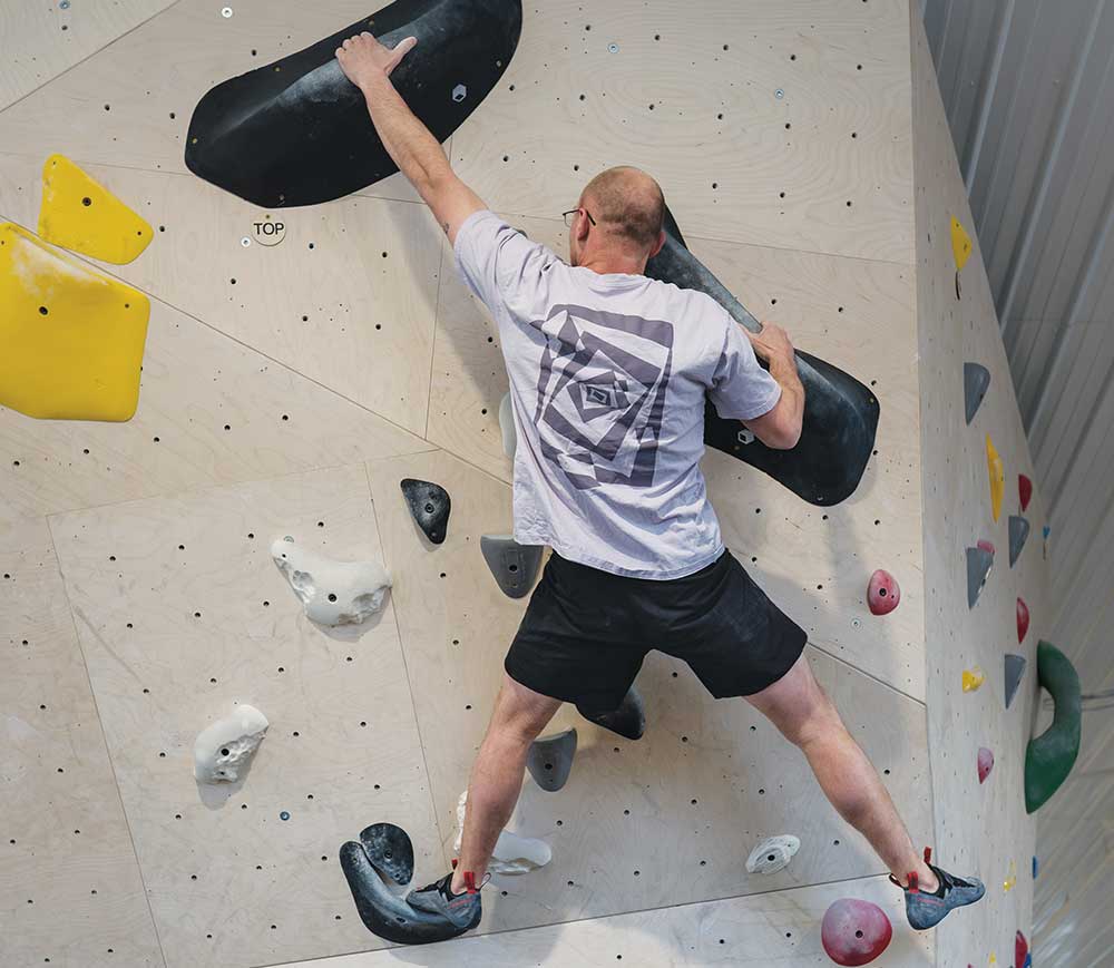 A man climbs up a rockwall at Bluestem Boulders in Ames, Iowa.