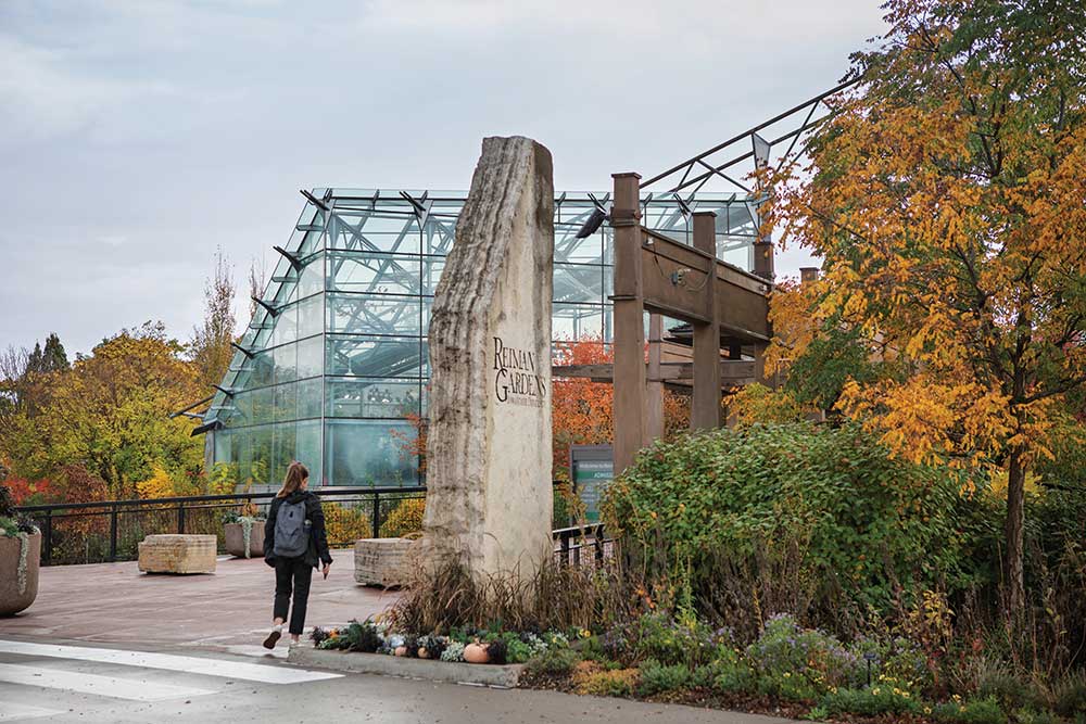 Girl walks through Reiman Gardens at Iowa State University to get to class.