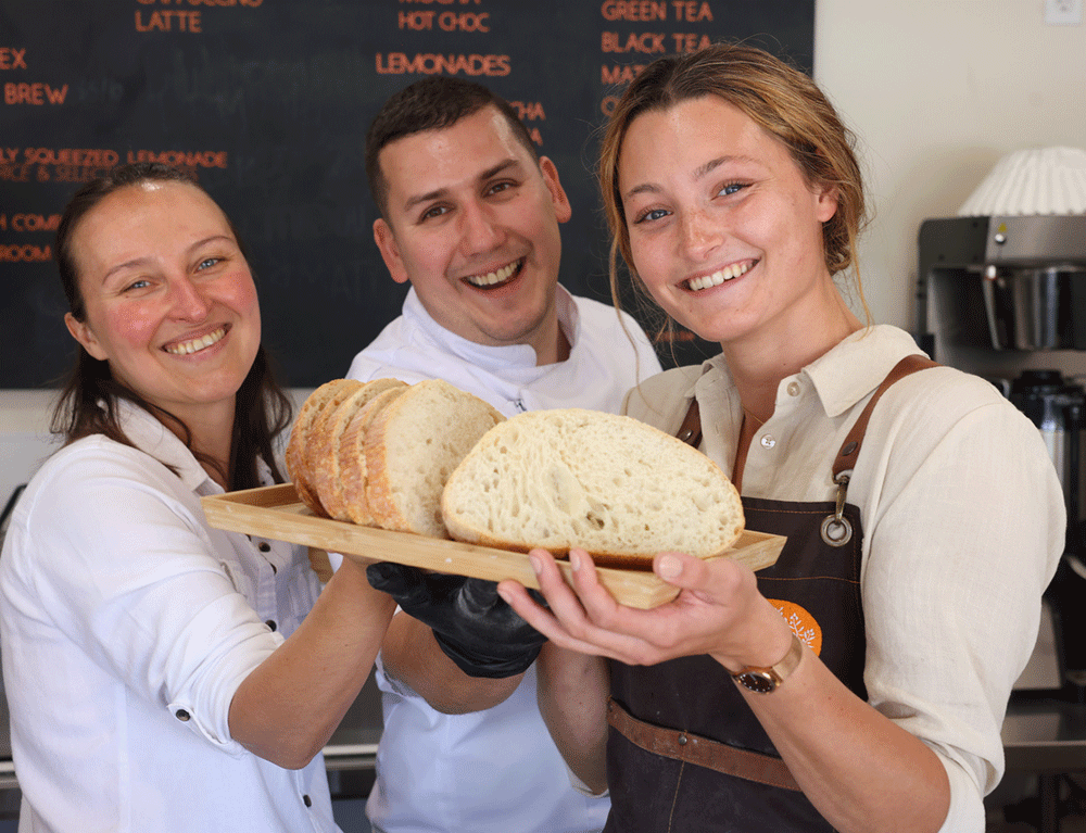 Manager Madison Gillis, right with restaurant co-owners Natalia Iakovleva and Sergey Pokanevych with sourdough bread at Chef Sergey's Bakery in Midland, Michigan.