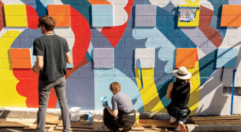 Artists from WSU work on painting the downtown wall mural project near the campus of Washington State University, Friday, September 24, 2021.