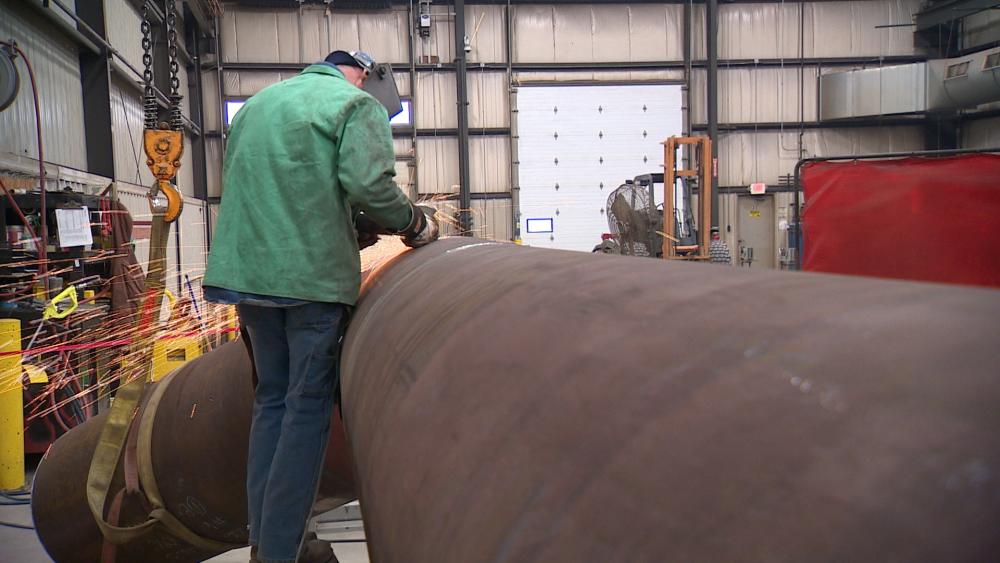 A UA 400 member is grinding and prepping the weld connection on a large-bore carbon pipe in a safe and controlled pipe fabrication shop, one of over a dozen in the jurisdiction.