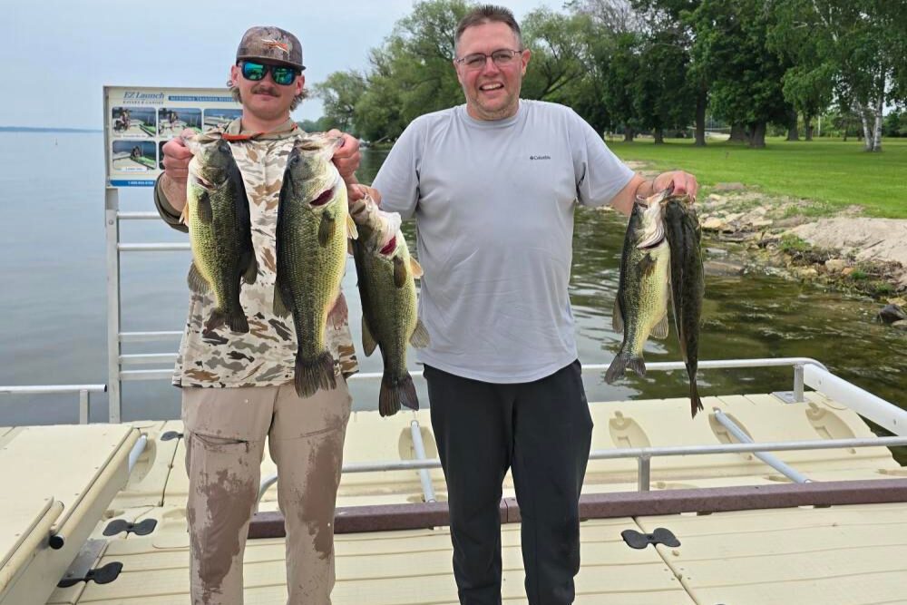 Travis Martin, a retired steamfitter now serving as a Local 400 business agent, poses with his son Jacob Martin, a Local 400 steamfitter apprentice, beside one of Wisconsin's 15,000 lakes with their prize-winning largemouth bass.