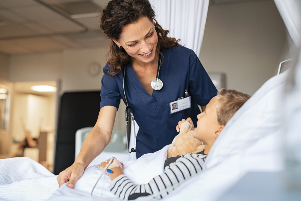 nurse taking care of boy in hospital bed