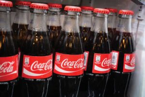 Glass bottles of famous coca-cola drink in the fridge.