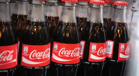 Glass bottles of famous coca-cola drink in the fridge.