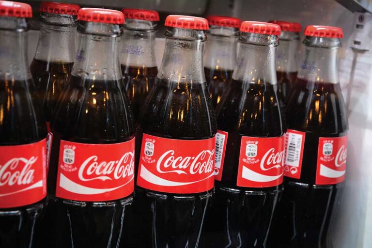Glass bottles of famous coca-cola drink in the fridge.
