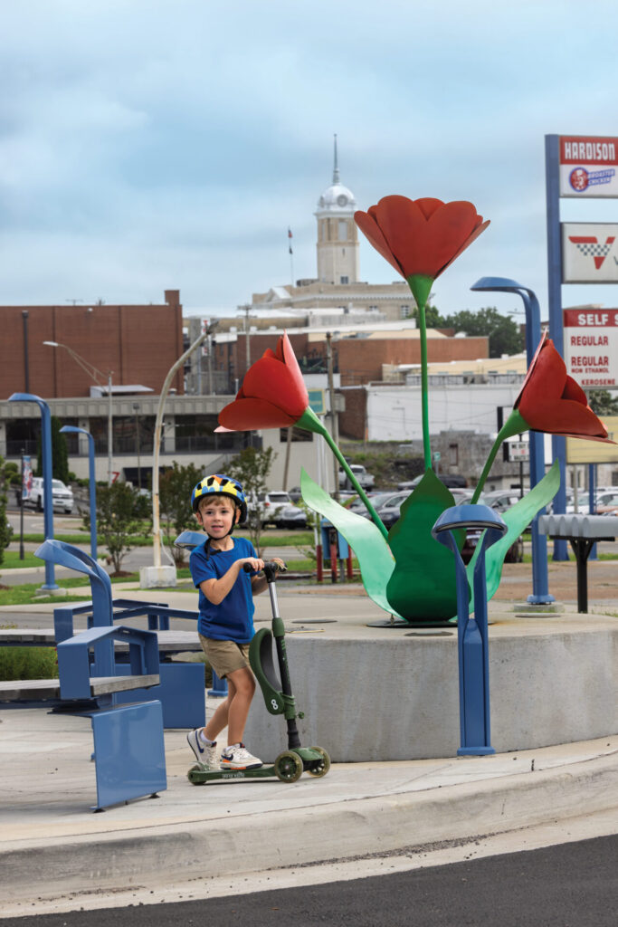 Brooks Tallent, 4, rides his scooter next to the Dancing Poppies sculpture on South Garden Street in the Arts District of Columbia.