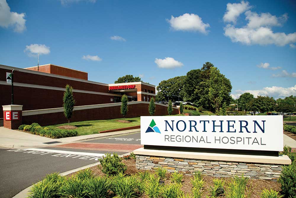 xterior view of the main entrance to Northern Regional Hospital building under a blue sky.