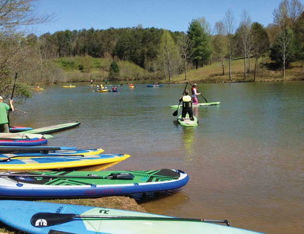 People kayak and paddleboard along the Yadkin River in Surry County, NC.