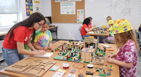 Instructor helping kids at a classroom table