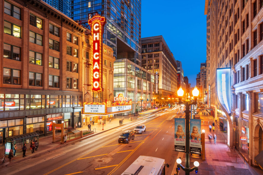Chicago, Illinois, USA - May 10, 2018: Traffic passes the landmark Chicago Theatre on State Street at twilight. The historic theater dates from 1921.