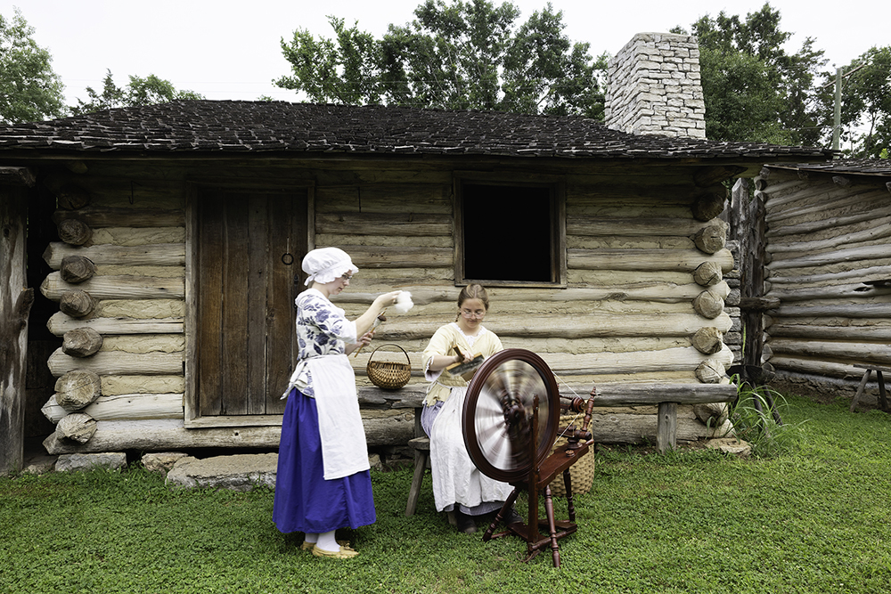 Lilly Waldron, left, uses a drop spindle as Sarah Lytle uses carders on wool while making thread for clothing at Mansker Station in Goodlettsville, TN.