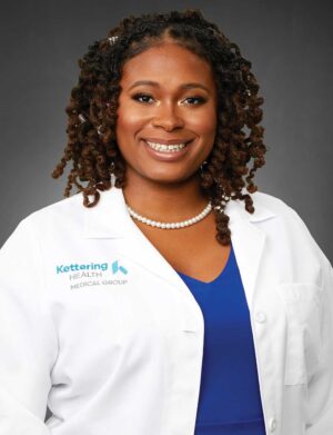 Professional headshot of Dr. Rachelle Dulan-Hood wearing a white lab coat and blue top.