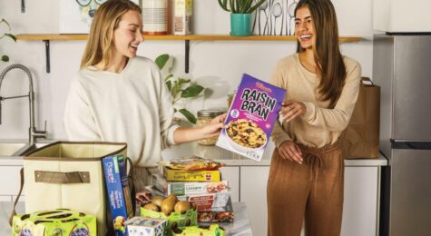two women unload grocery items, many with packaging created by Graphic Packaging
