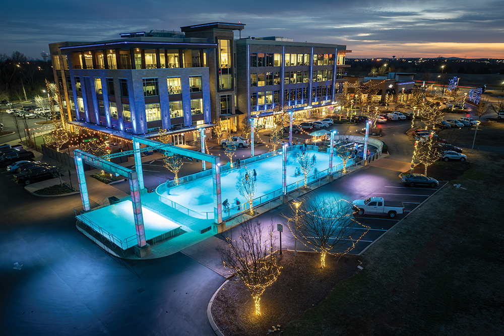 In this drone photo, visitors ice skate at dusk during Winterfest at Fountains at Gateway in Murfreesboro, Tennessee.