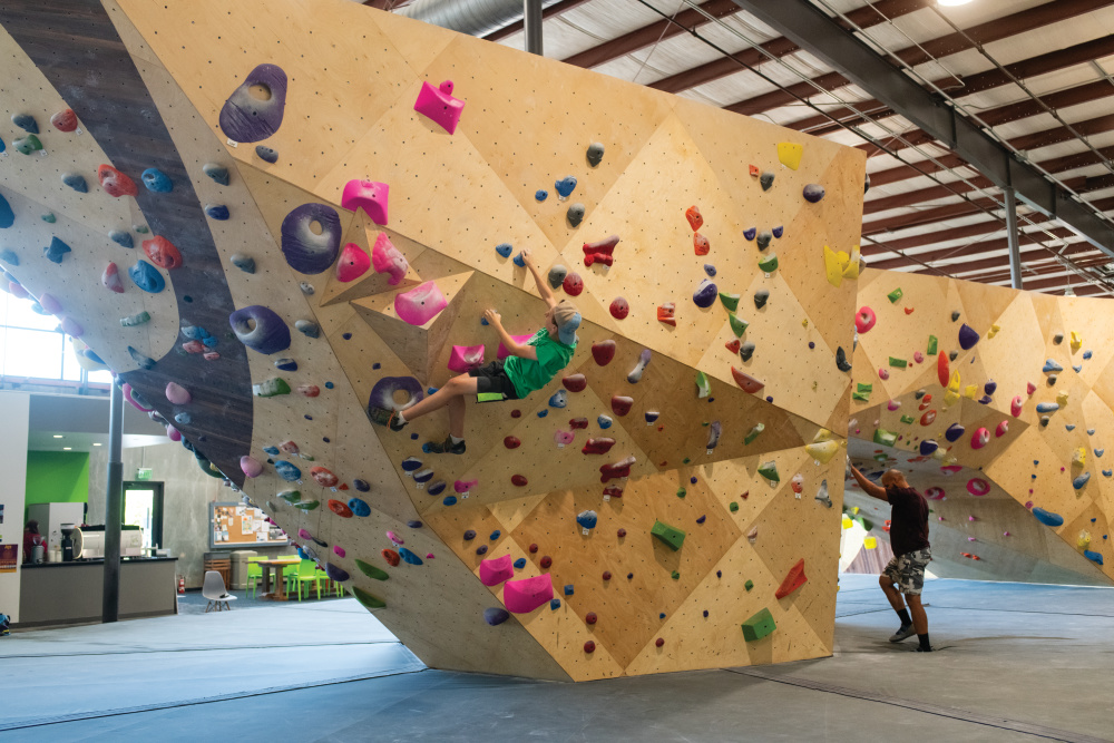 Two men climbing at an indoor rock wall.