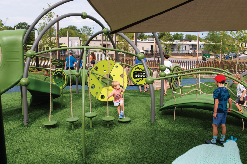 Kids playing on playground equipment at Unity Park in Greenville, South Carolina