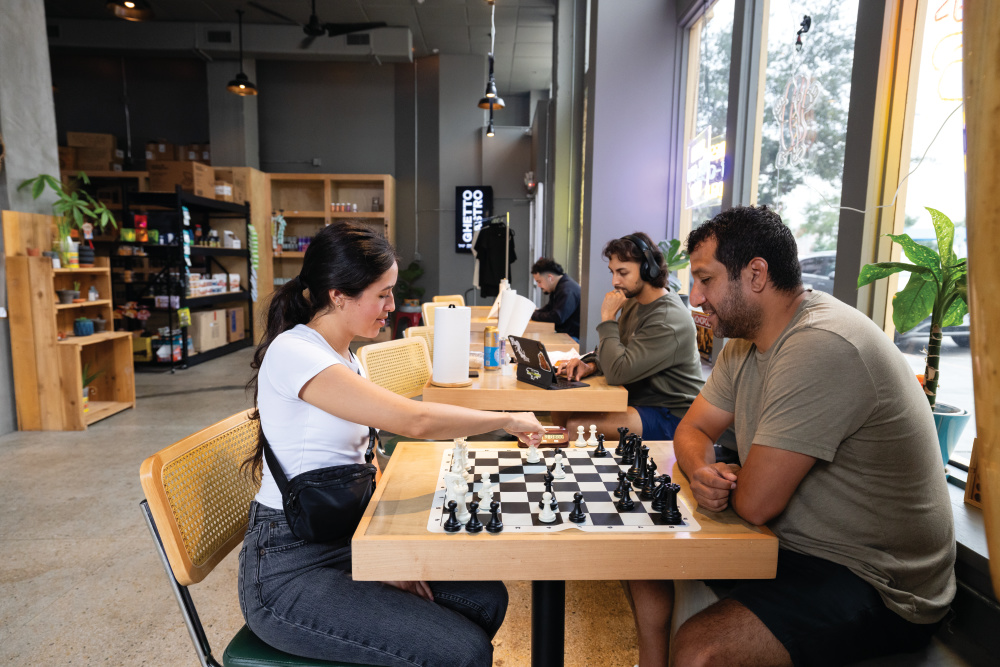 Briana Herrera and Joel Orgas play chess at Community Grocery in downtown Corpus Christi.