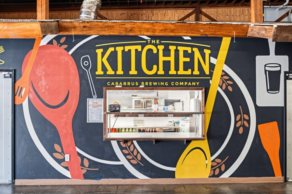 The drink station at Cabarrus Brewing Company, marked by a huge Kitchen sign