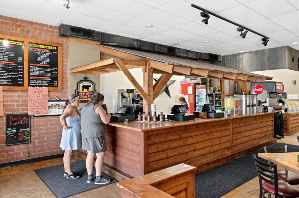 Two individuals ordering food at The Smoke Pit